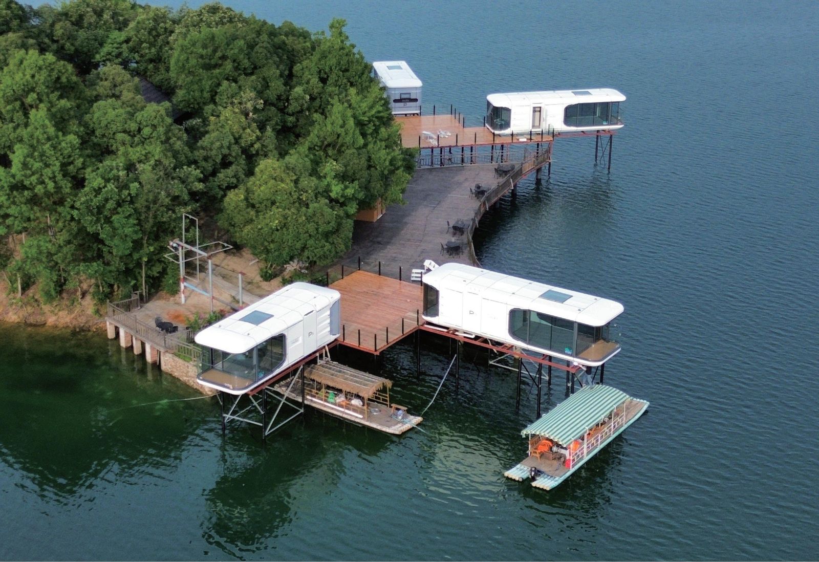 Waterfront capsule lodge project with elevated prefab units over water