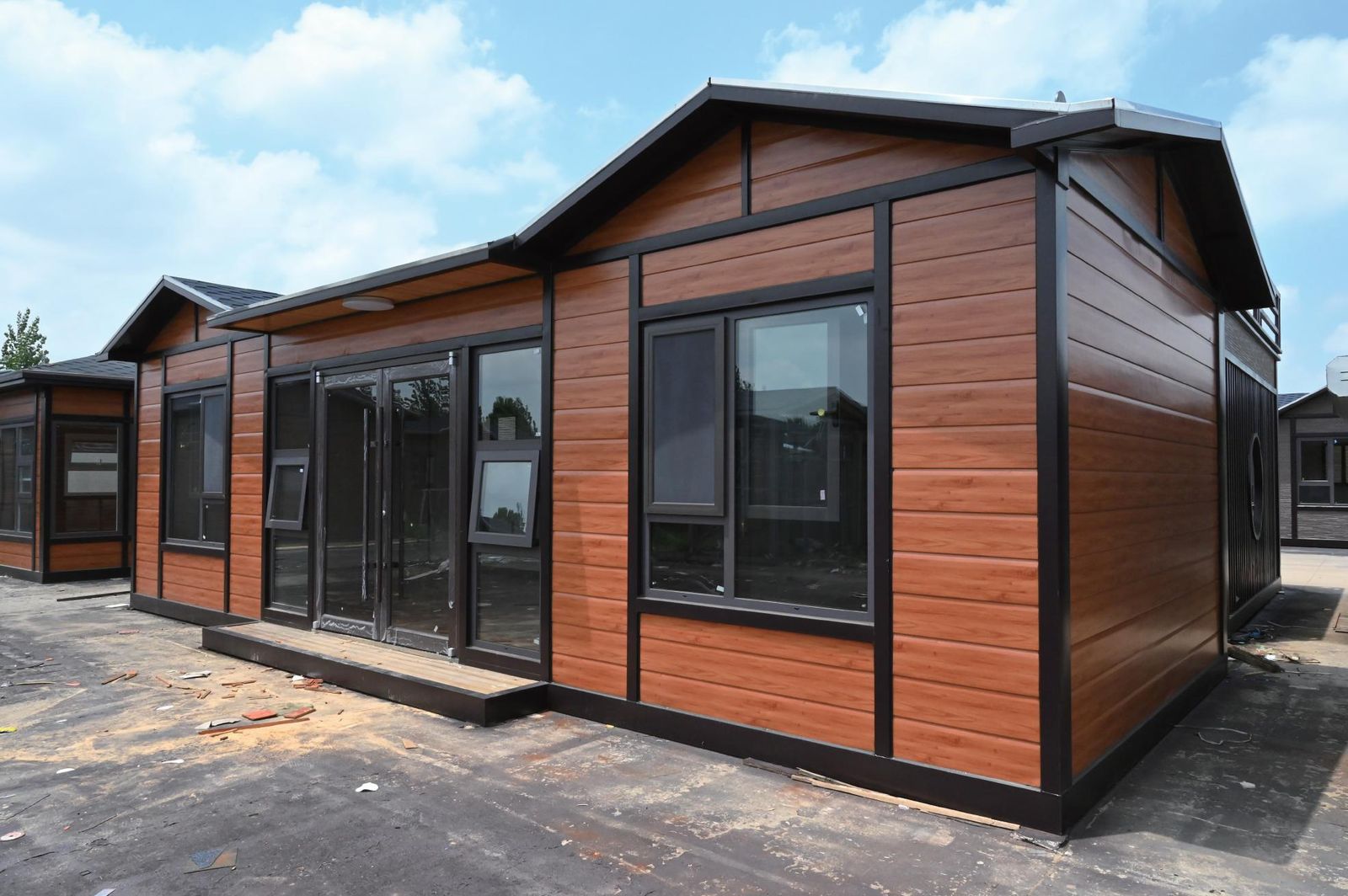 Integrated panel prefab house with wood-grain siding and black frame
